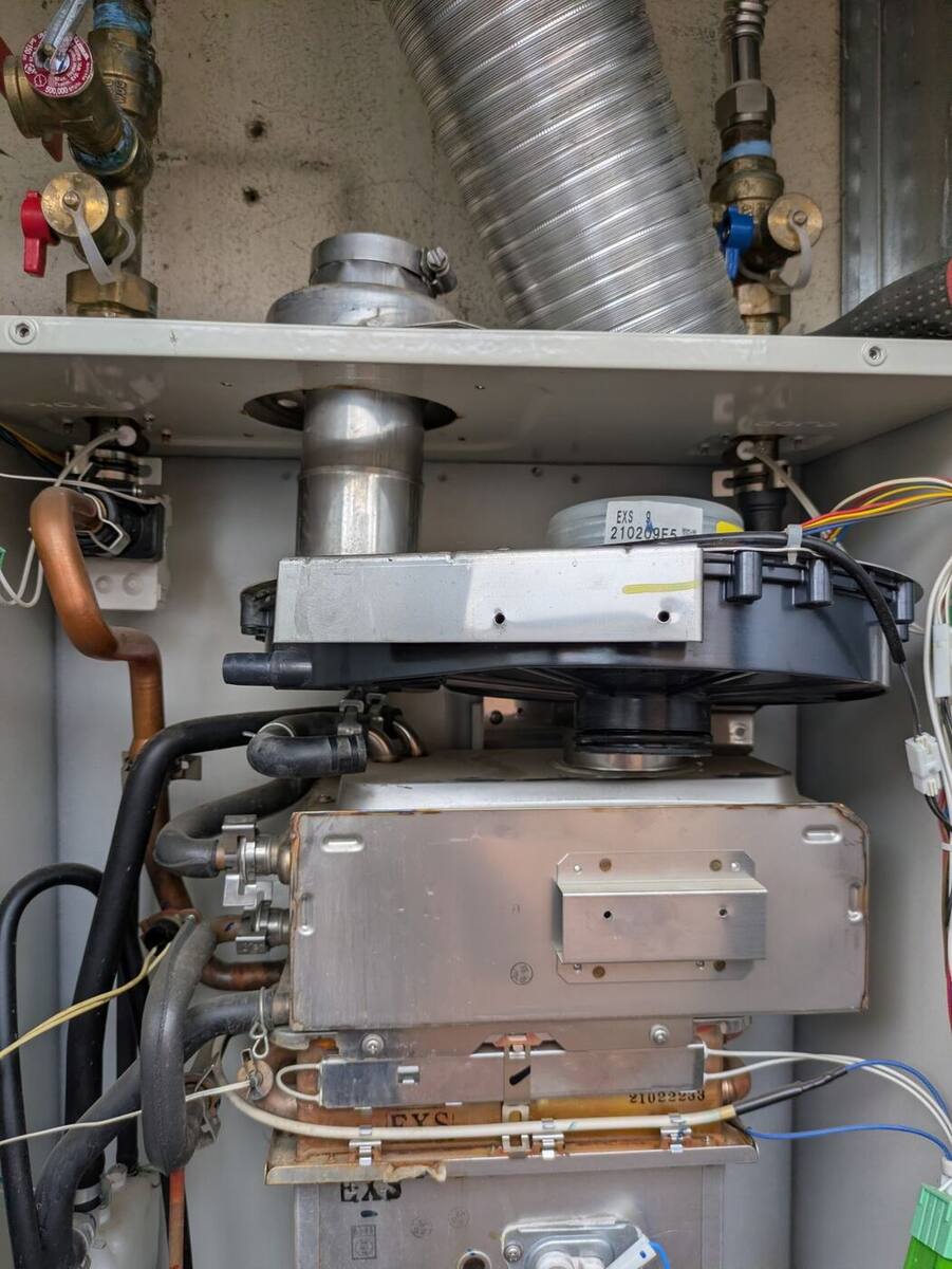 Tankless water heater opened up for annual maintenance in Bakersfield, showing the blower and heat exchanger